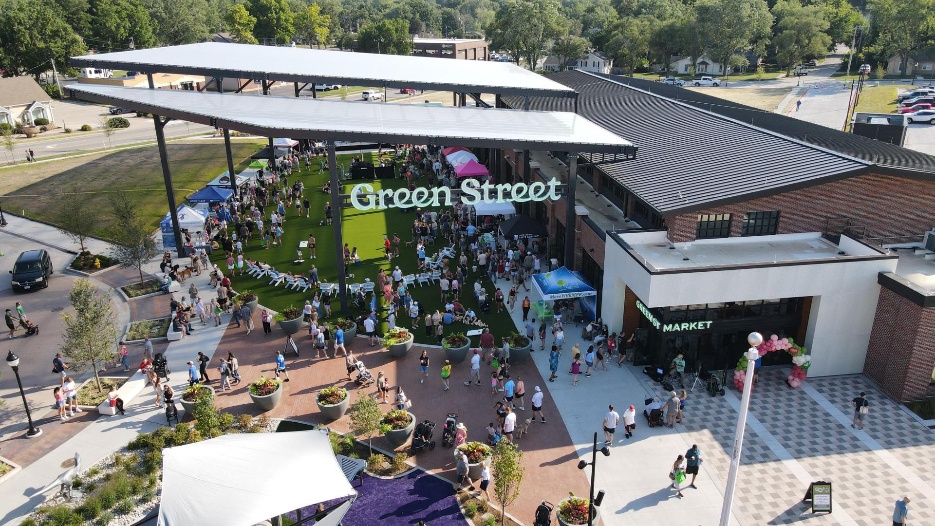 drone photo of a market building with an overhead pavilion and visitors walking around